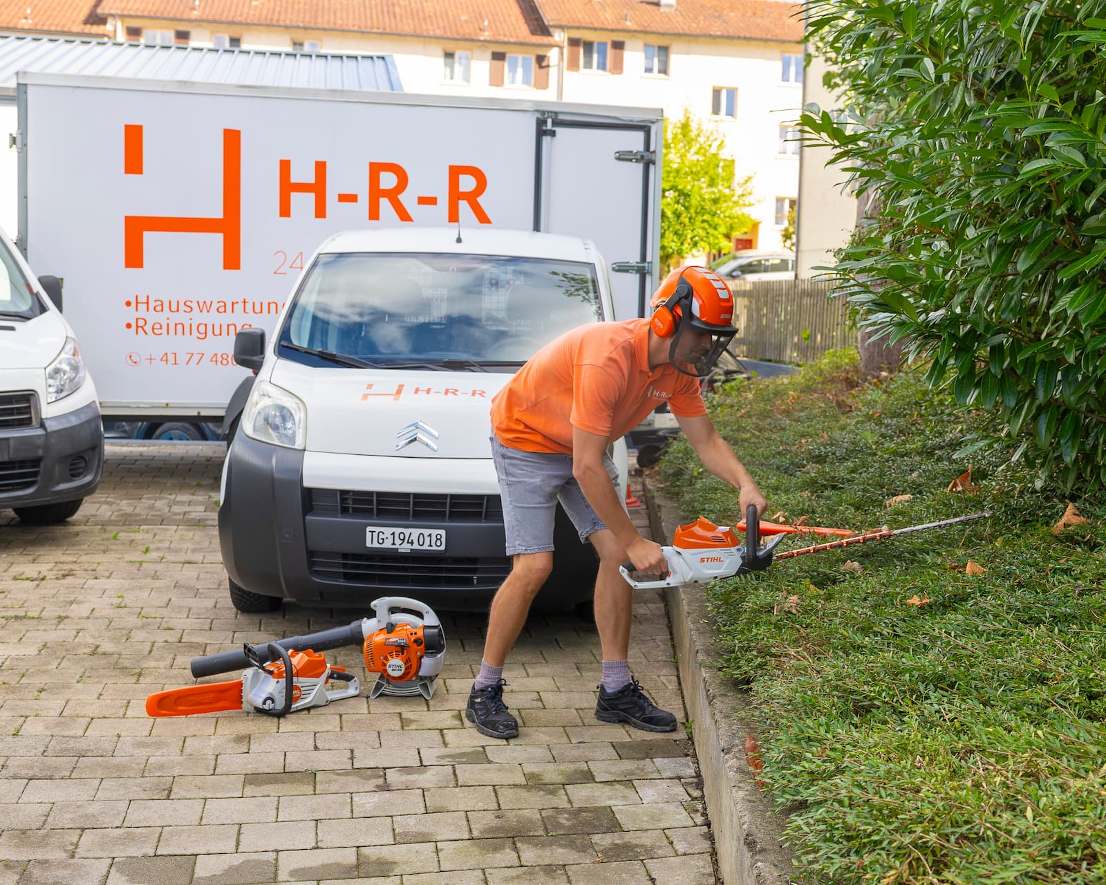 Mitarbeiter von H-R-R beim Heckenschneiden